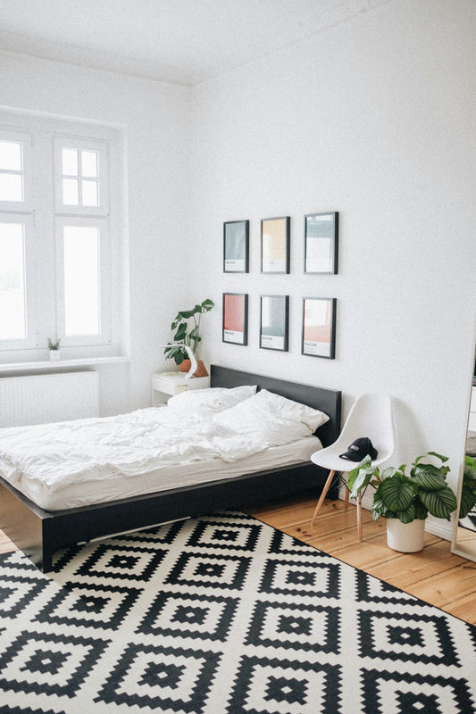 Black platform bed with white mattress inside a bedroom