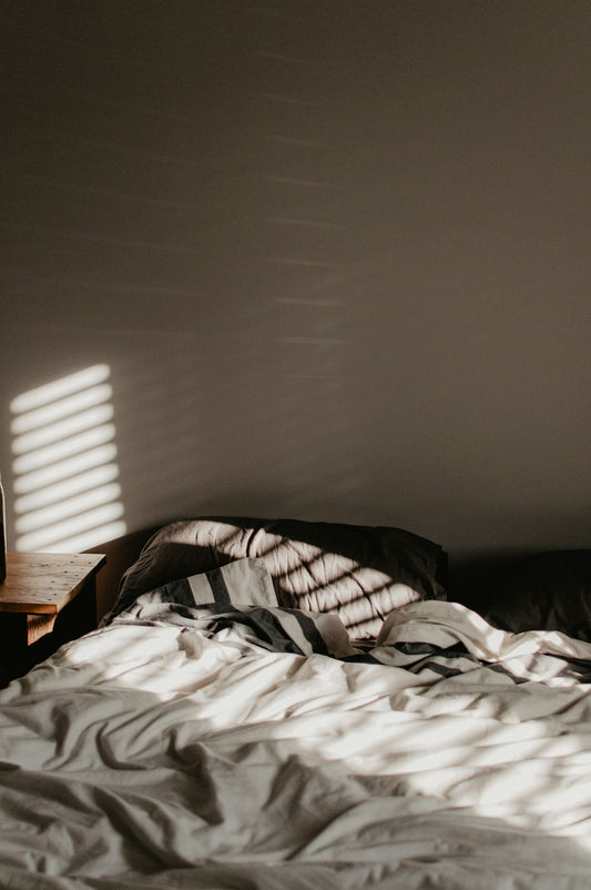 Sunlight streaming across a comfortable made bed